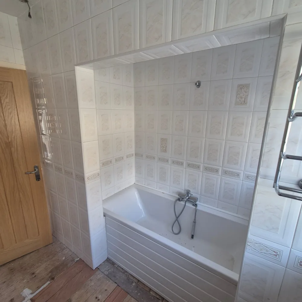 The old bathroom with a dated bath and patterned tiles