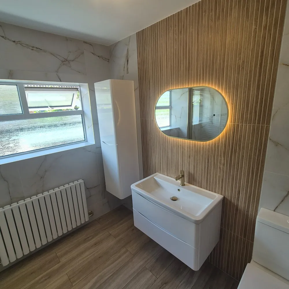 Finished vanity wall with LED mirror, wood-effect panel and column radiator