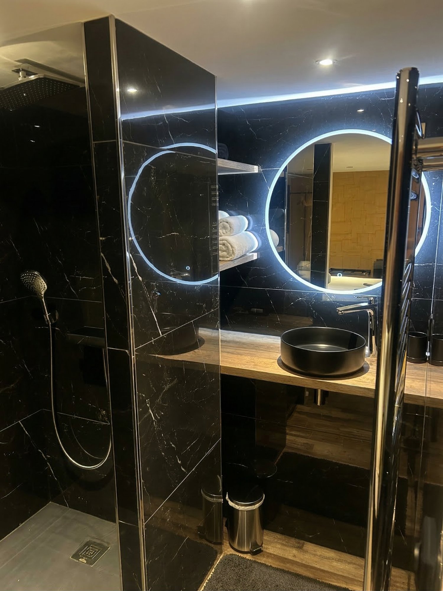 Black marble bathroom with LED ring mirror