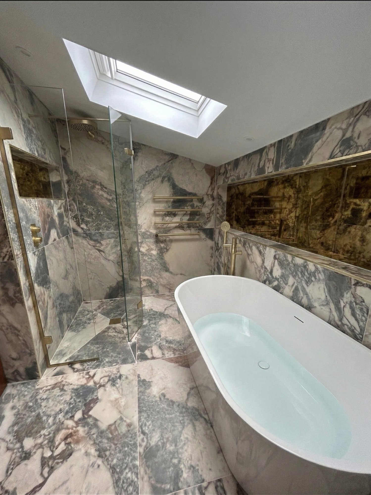 Luxury marble bathroom with gold fittings and freestanding bath