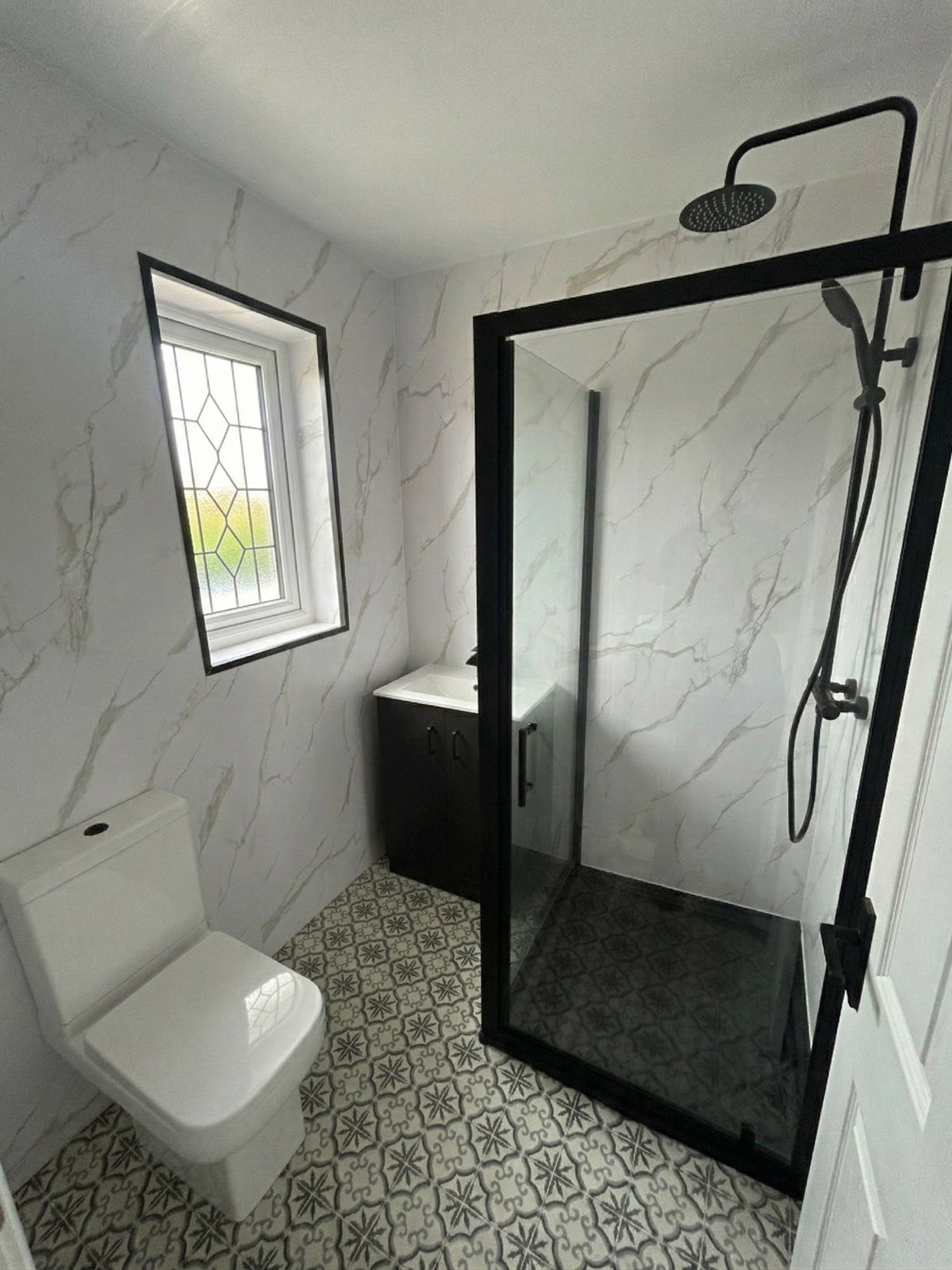 White marble shower room with patterned floor tiles