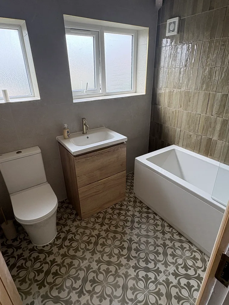 Holly's finished bathroom by Danvers Northwest, patterned floor, oak vanity and olive tiling
