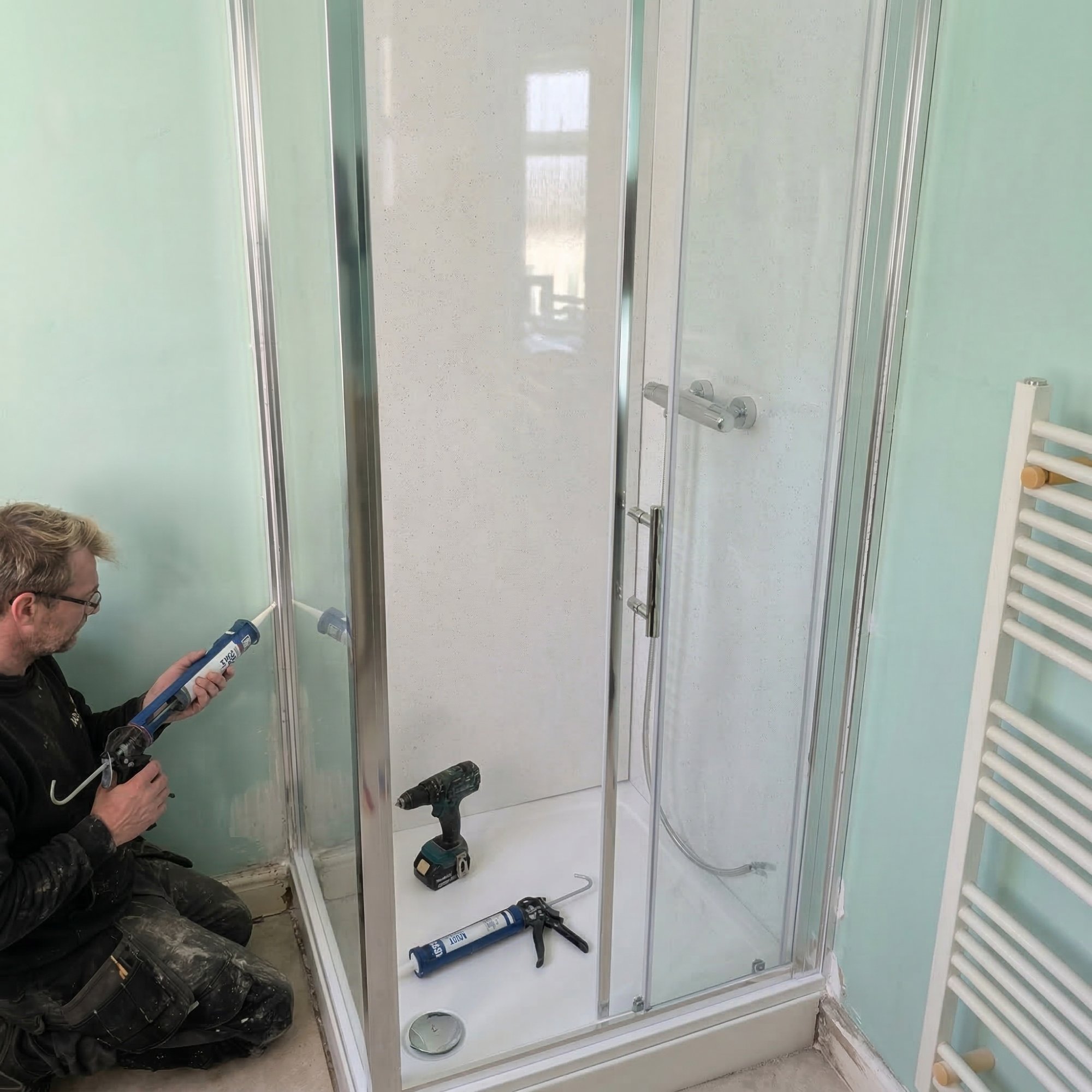 Danvers team member installing a shower enclosure on site