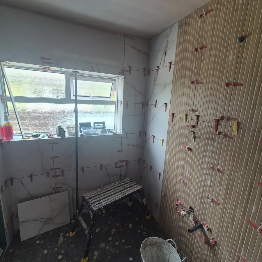 Marble and wood-effect tiles set on levelling clips for a flat finish